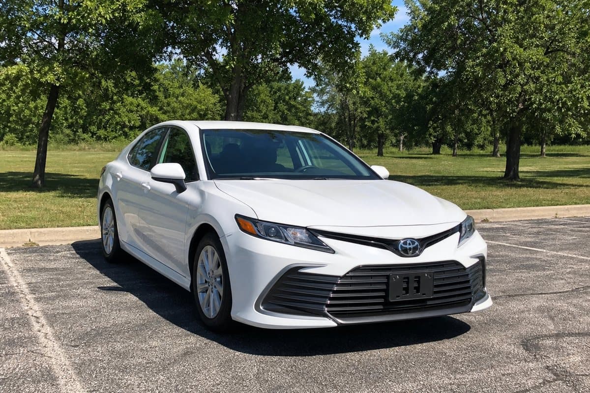 A white Toyota Camry in a park parking lot